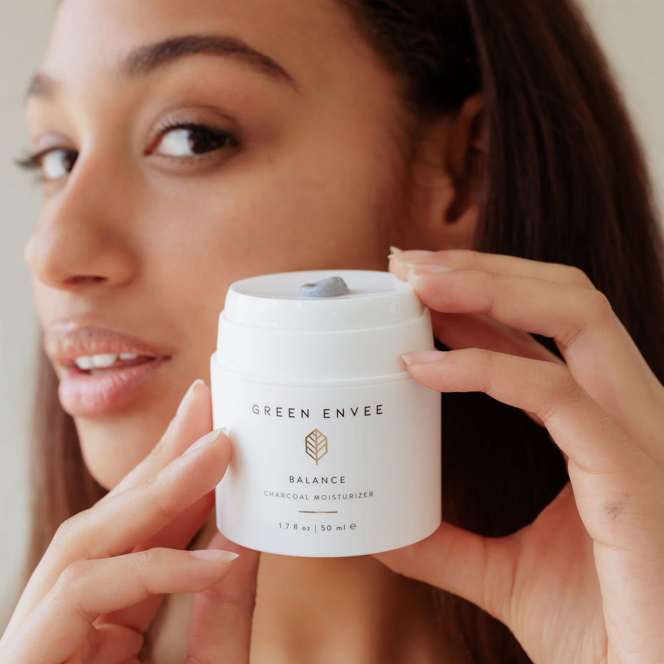 Women holding charcoal moisturizer branded with Green Envee 