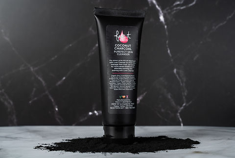 A tube of Coconut Charcoal Purefect Cleanser standing upright with a dark, marbled background. The cleanser appears to be black in color, consistent with the charcoal powder used in it.