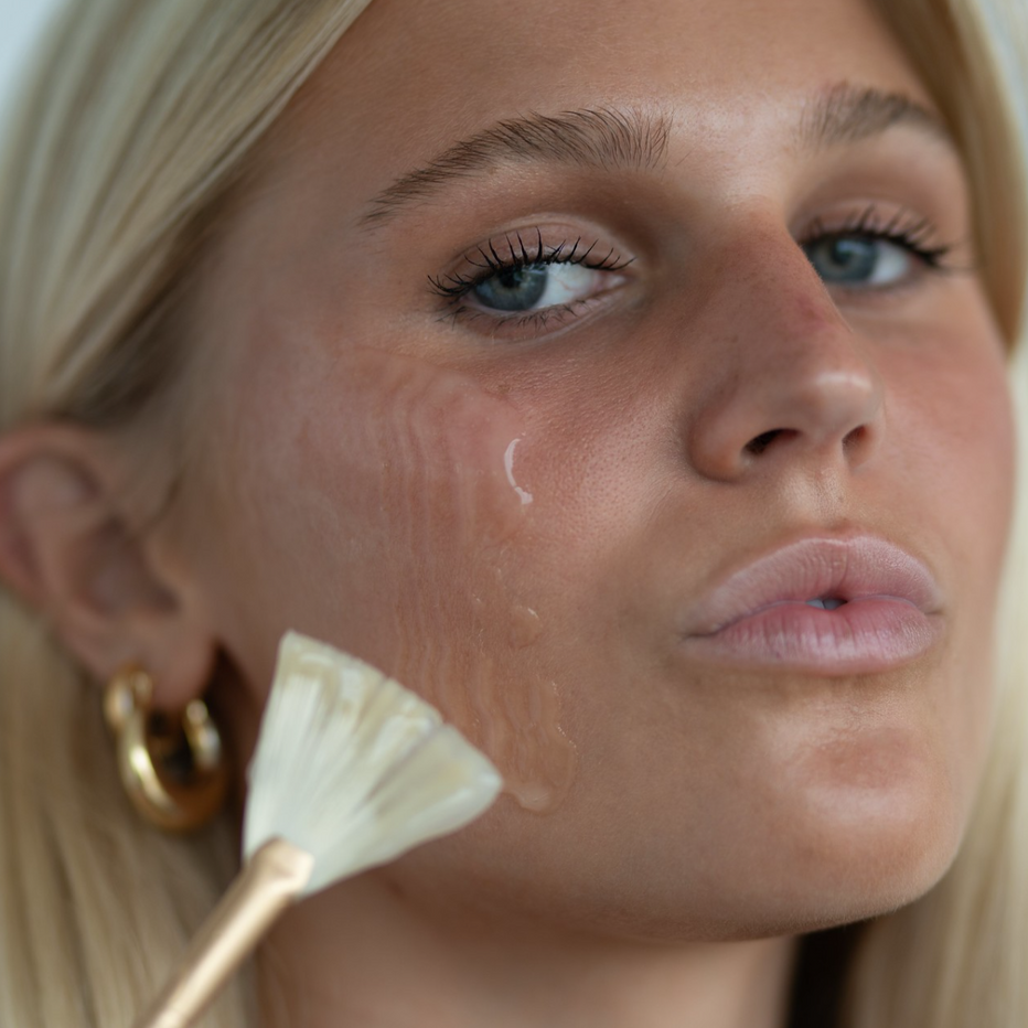 Woman applying Green Envee Firm Collagen Gel Masque with a brush to her face