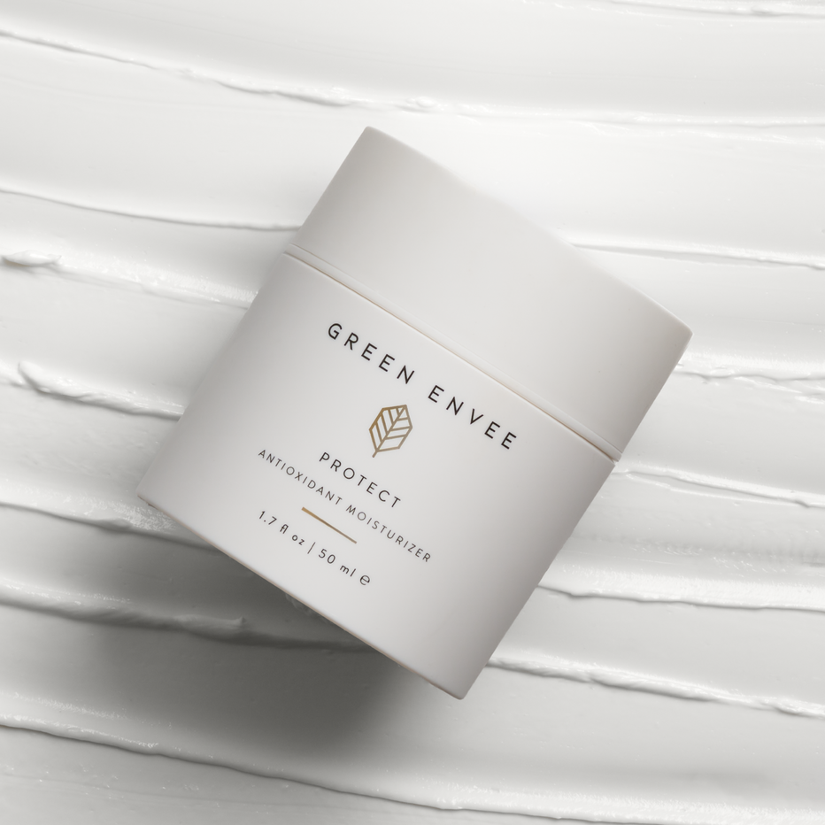 container of protect antioxidant cream branded Green Envee . White creamy background