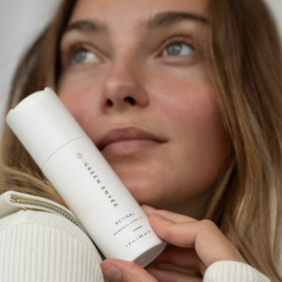 Person holding a white skincare product with 'Green Envee' branding.